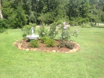 Round landscape bed with stone border and plants