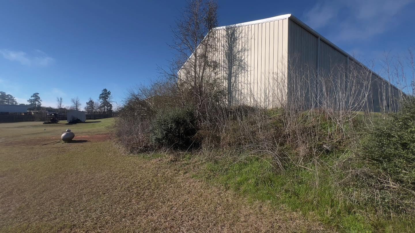 Back side of metal building before brush clearing